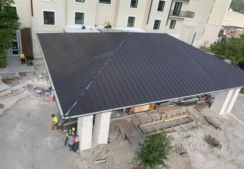 Metal roofing installation team working on a commercial building in Progreso